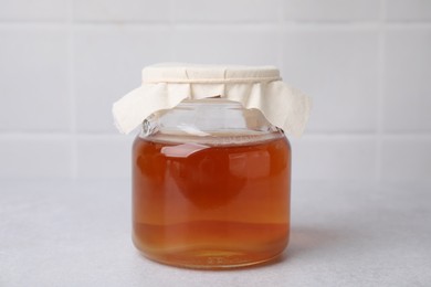 Photo of Tasty kombucha in glass jar on white table