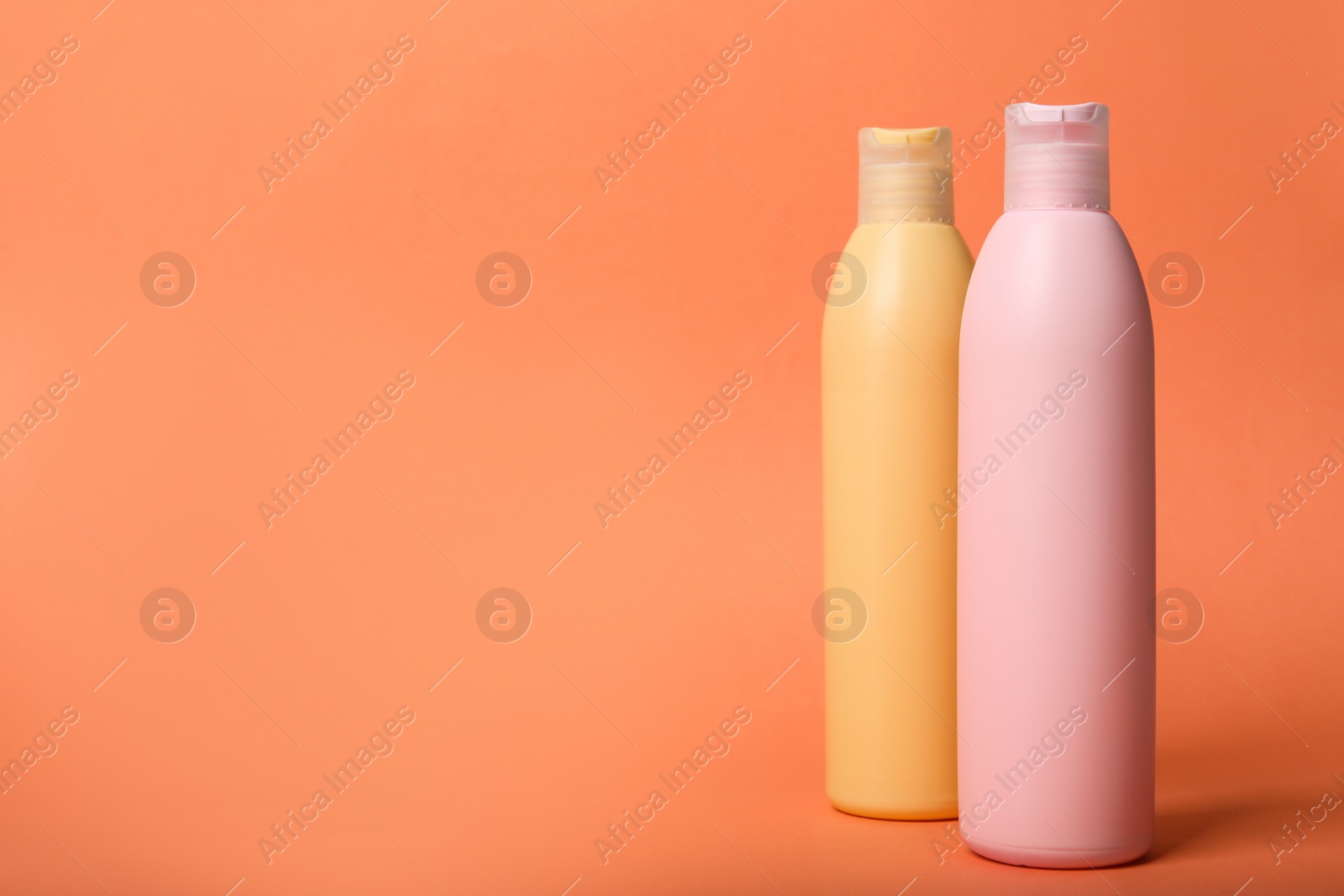 Photo of Bottles with cosmetic products on orange background. Mockup for design