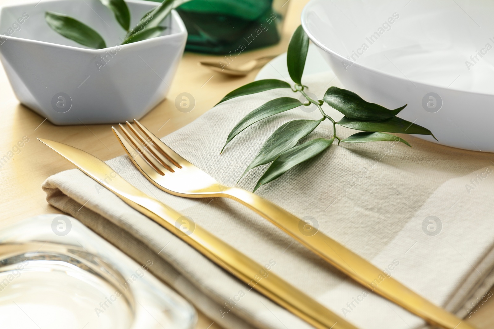 Photo of Elegant table setting with green leaves, closeup