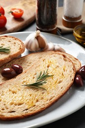 Tasty bruschettas with oil and rosemary on plate, closeup