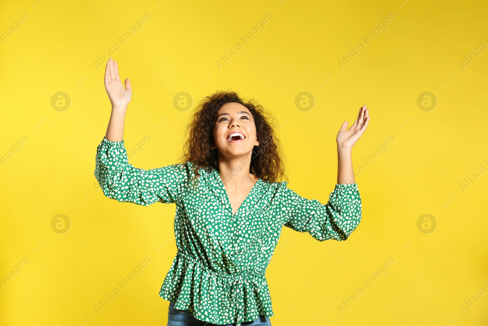 Photo of Portrait of emotional African-American woman on color background