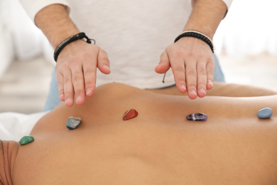Photo of Man during crystal healing session in therapy room, closeup
