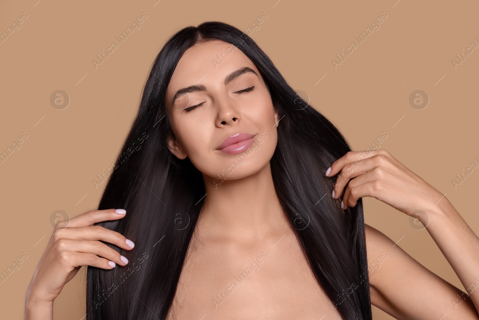 Photo of Portrait of beautiful young woman with healthy strong hair on beige background