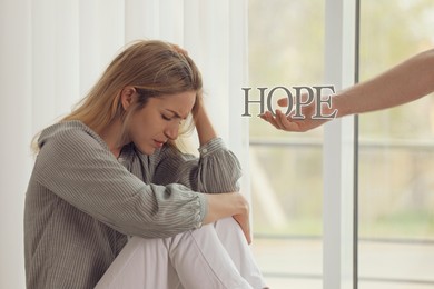 Image of Concept of hope. Man offering hand to upset woman indoors