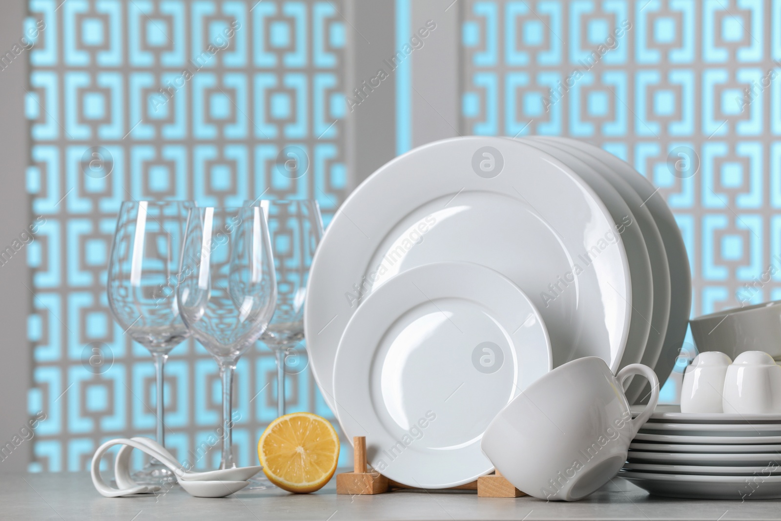 Photo of Set of clean dishware on light grey table