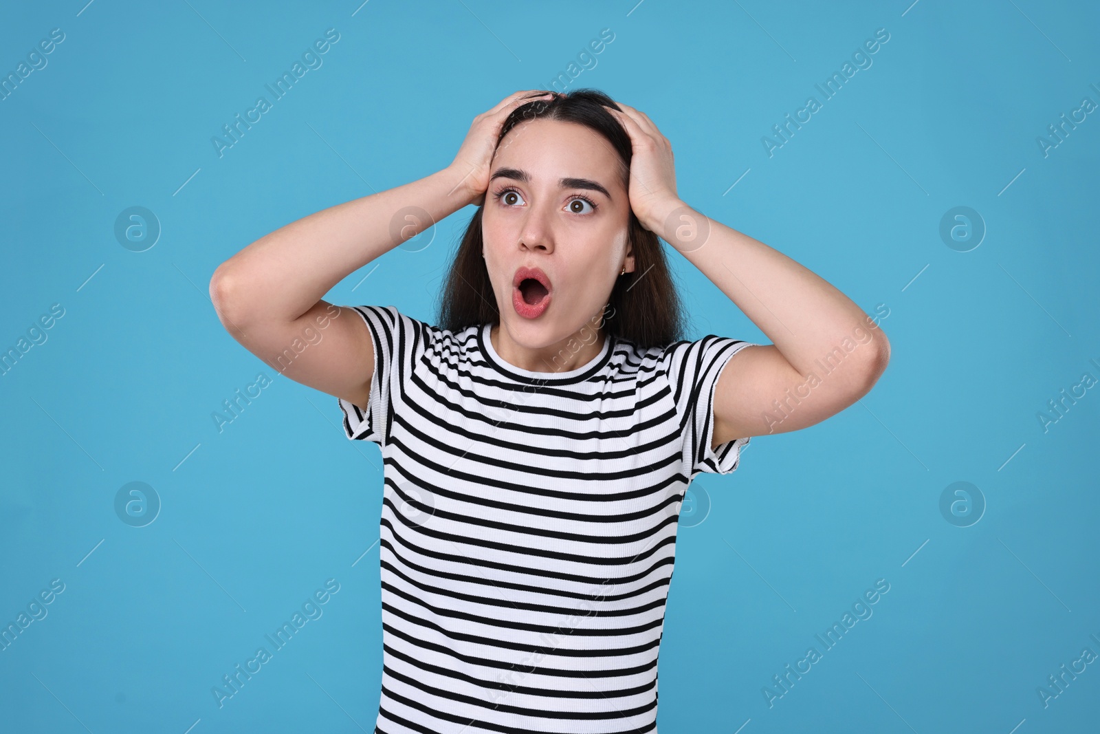 Photo of Portrait of surprised woman on light blue background