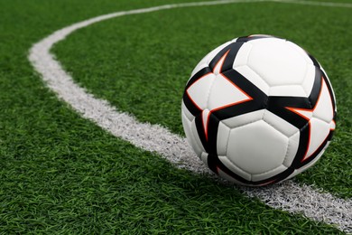 Photo of Soccer ball on green football field, space for text