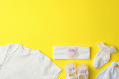 Photo of Flat lay composition with child's clothes on yellow background, space for text
