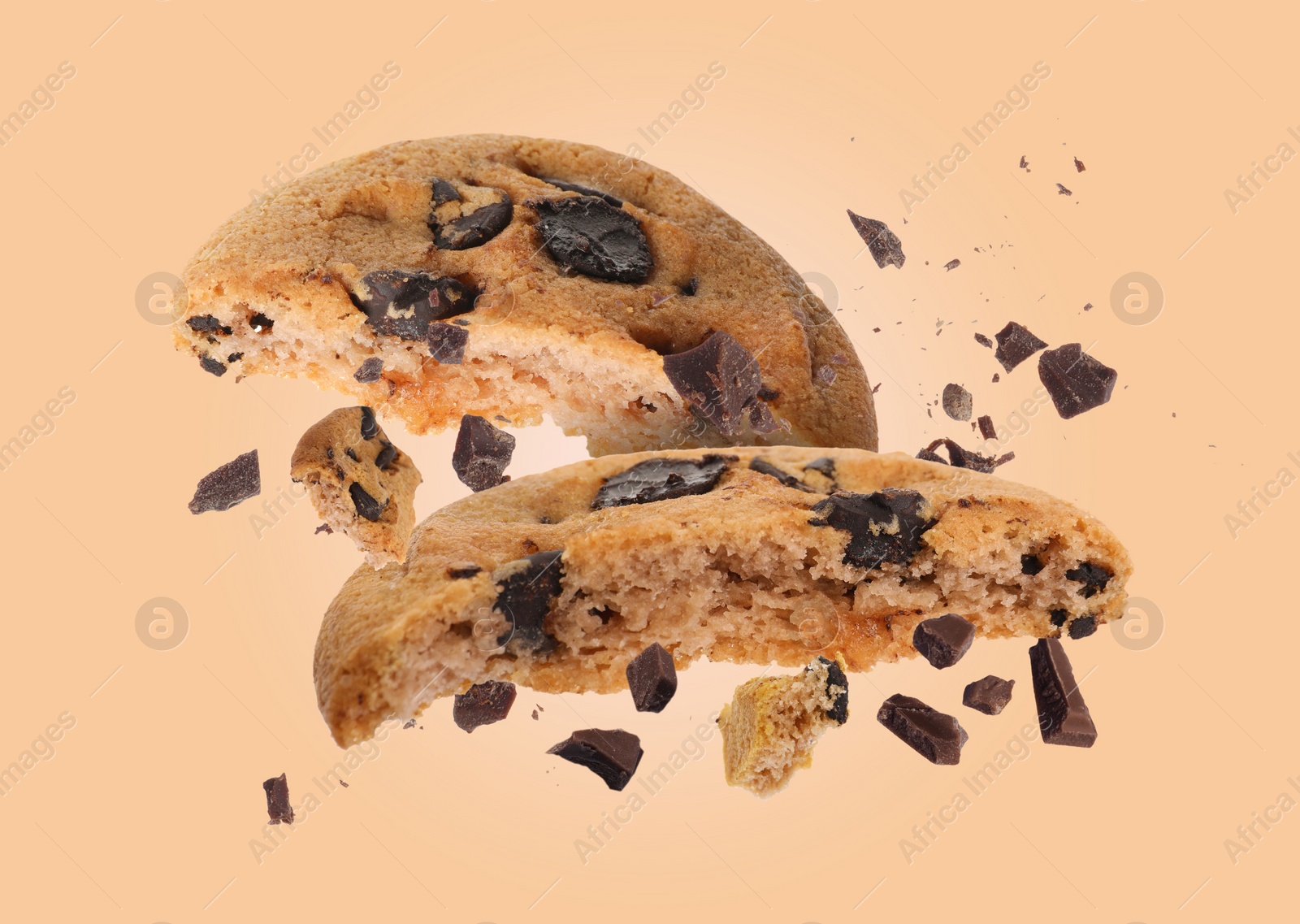 Image of Tasty chocolate chip cookies falling on pale light brown background