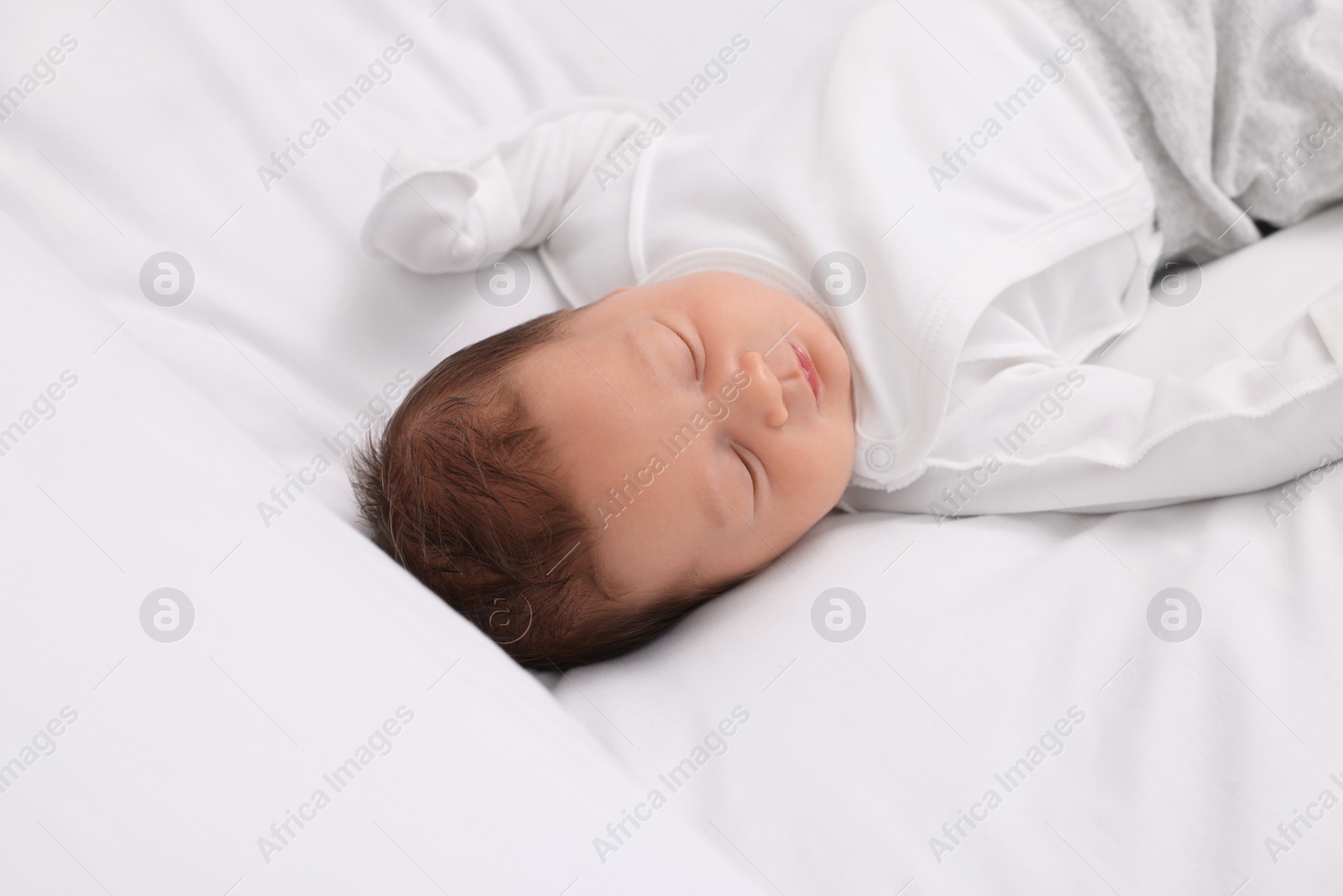 Photo of Cute newborn baby sleeping on white bed