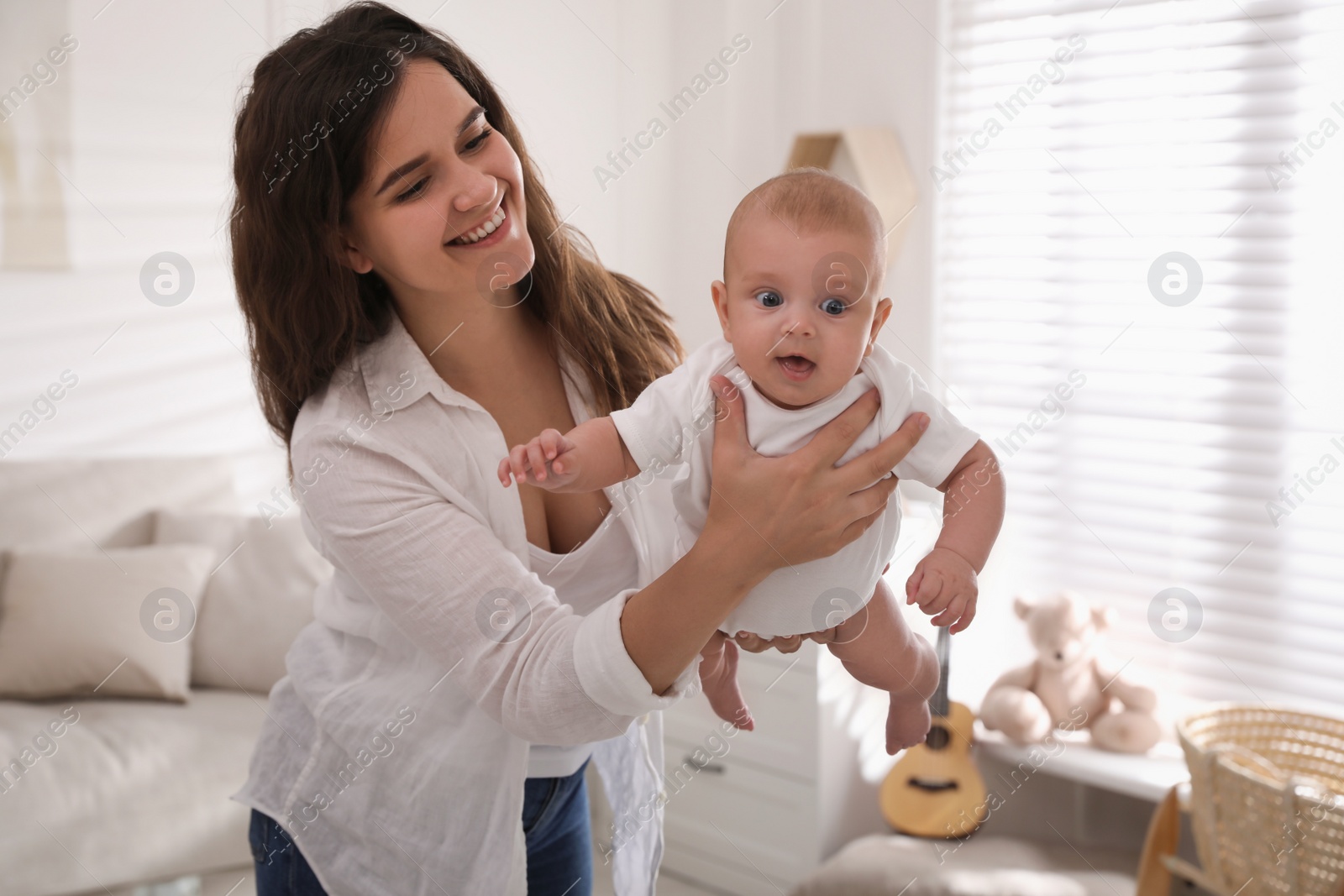 Photo of Happy young mother with her cute baby at home