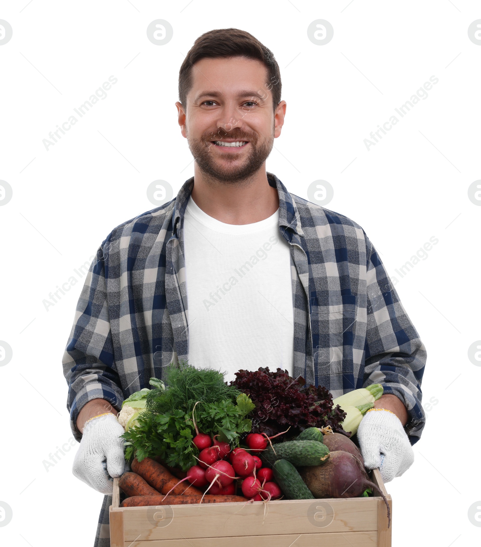 Photo of Harvesting season. Happy farmer holding wooden crate with vegetables on white background