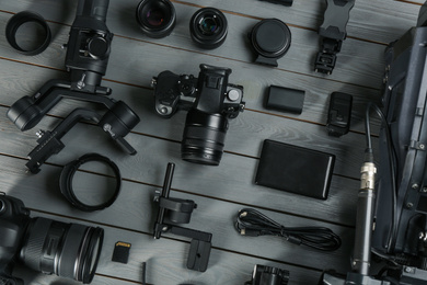 Photo of Flat lay composition with video camera and other equipment on grey wooden table