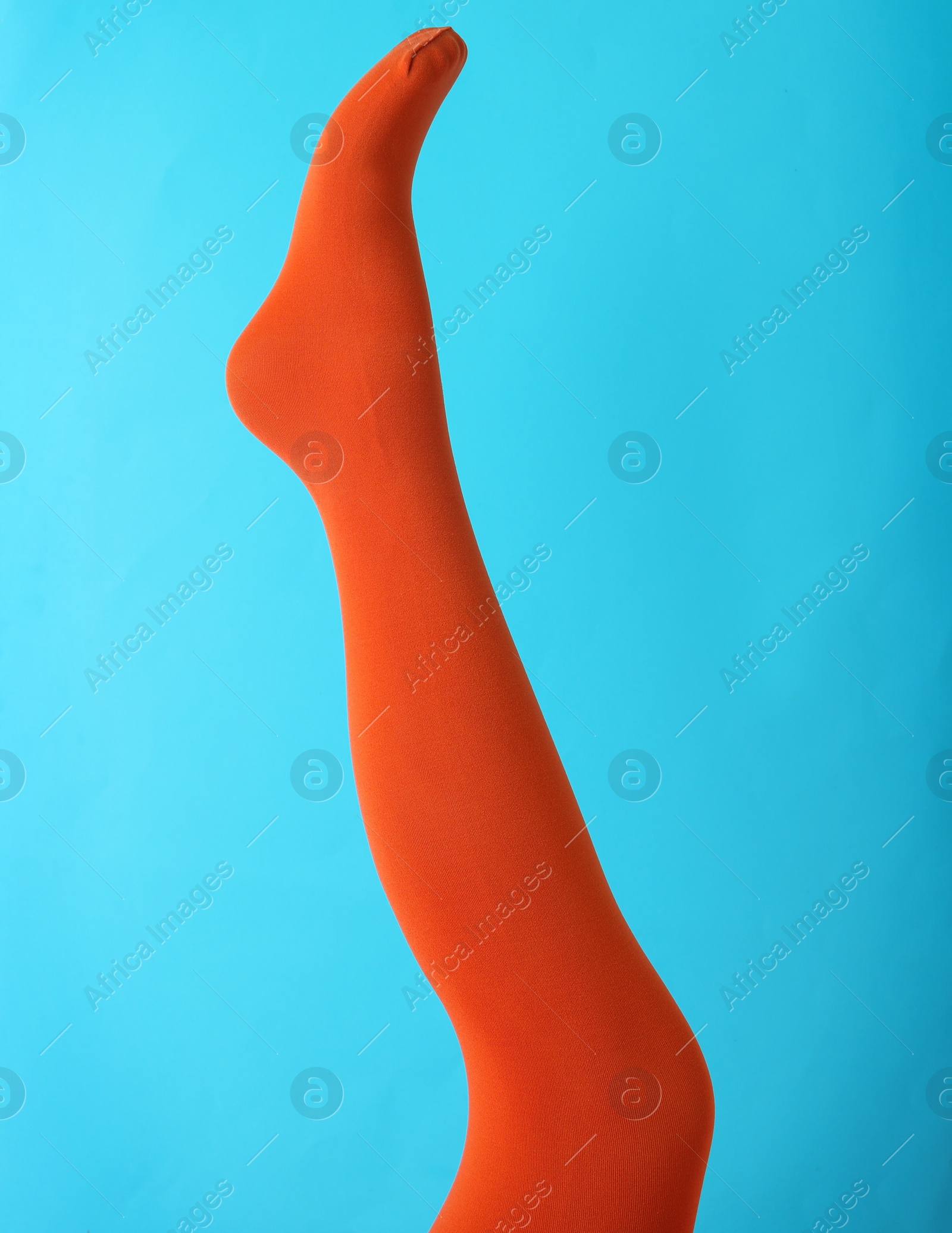 Photo of Leg mannequin in orange tights on blue background