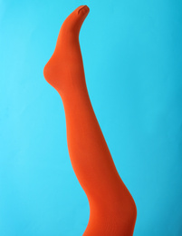 Leg mannequin in orange tights on blue background
