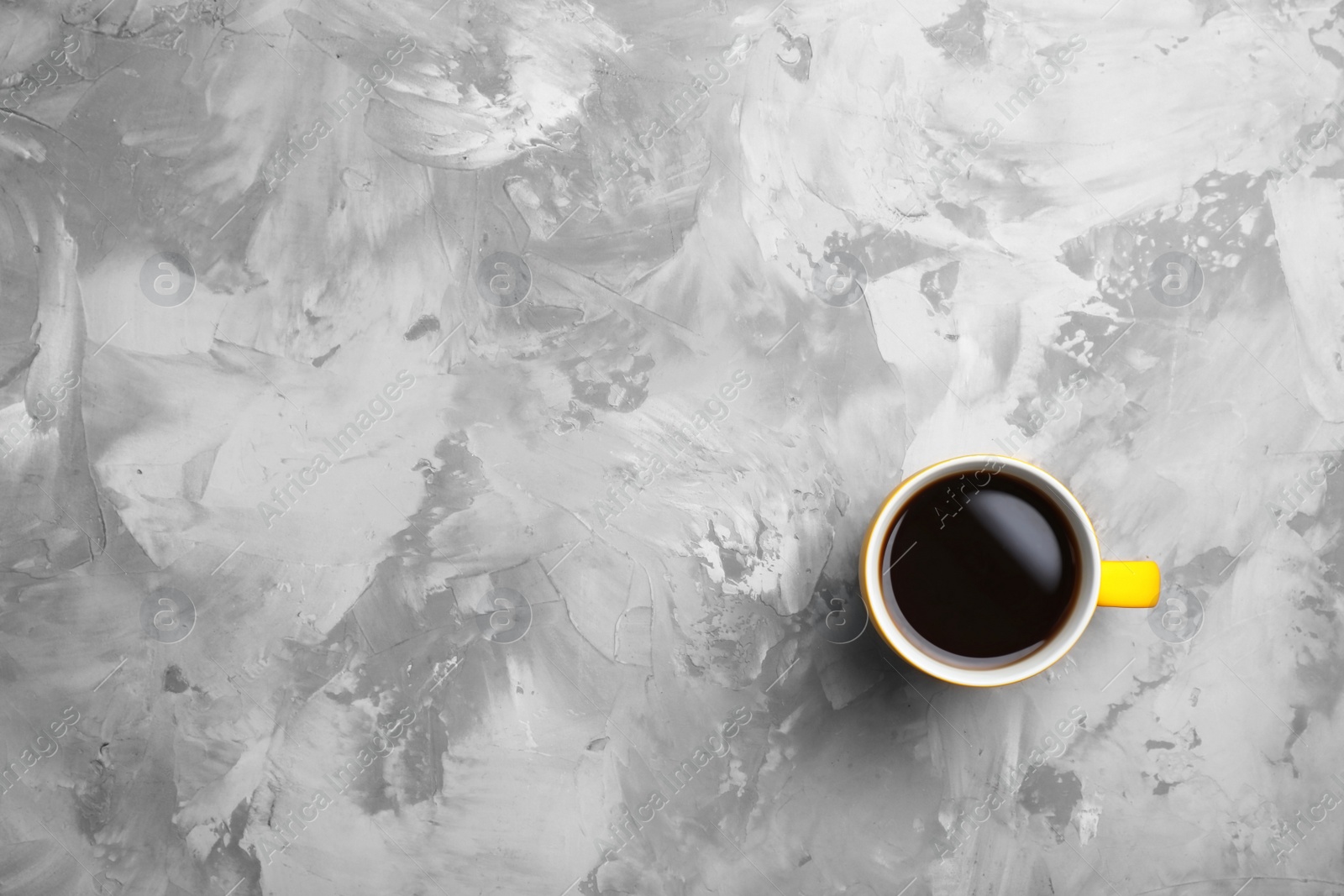 Photo of Ceramic cup with hot aromatic coffee on grunge background, top view