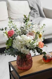 Photo of Bouquet of beautiful flowers on wooden table indoors