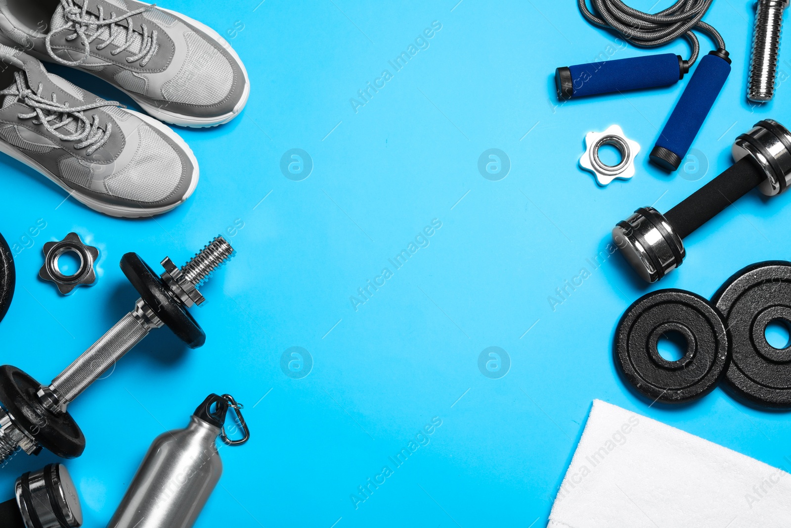 Gym equipment on light blue background, flat lay. Space for text Photo of Gym equipment on light blue background, flat lay. Space for text