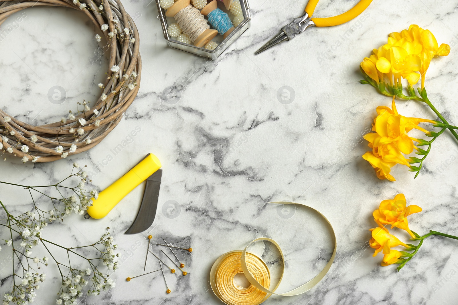 Photo of Florist equipment with flowers on marble background, top view