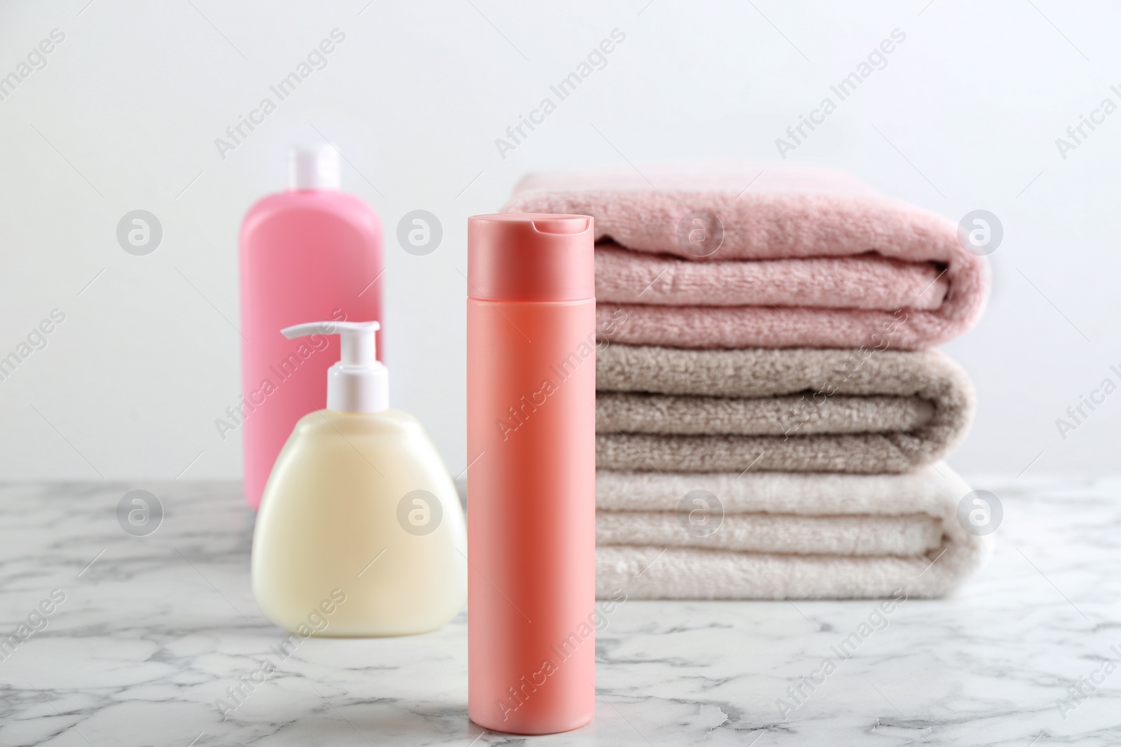 Photo of Fresh towels and toiletries on white marble table