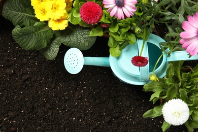 Flat lay composition with gardening equipment and flowers on soil