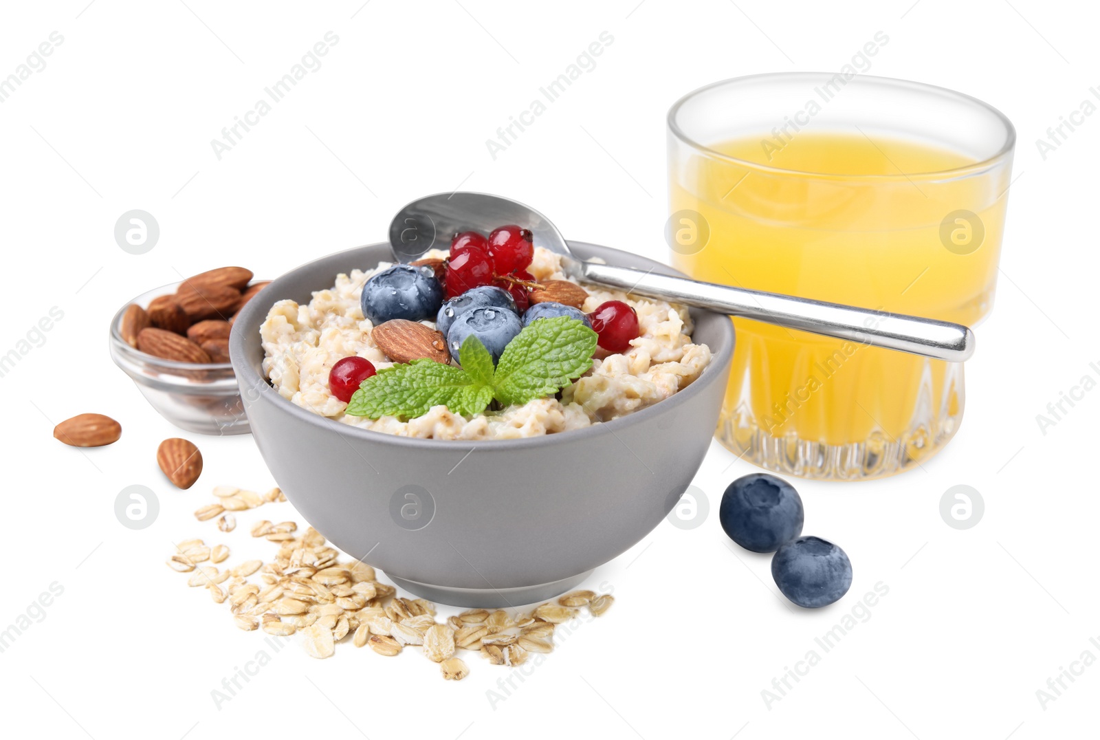 Photo of Oatmeal served with berries, almonds and honey on white background