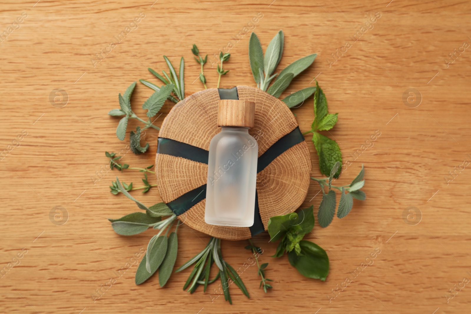 Photo of Flat lay composition with bottle of essential oil and fresh herbs