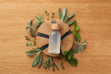 Flat lay composition with bottle of essential oil and fresh herbs