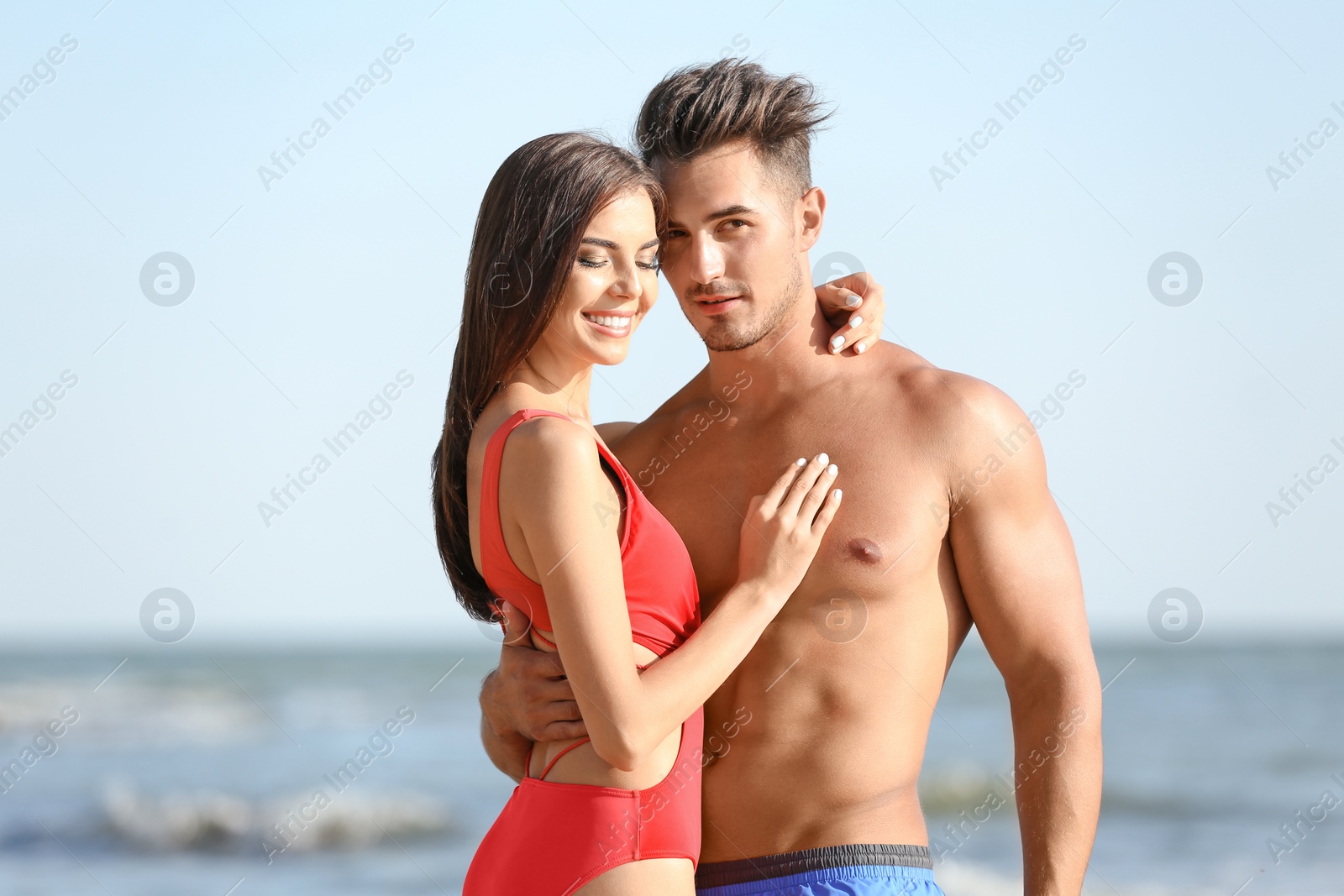 Photo of Happy young couple posing near sea on beach