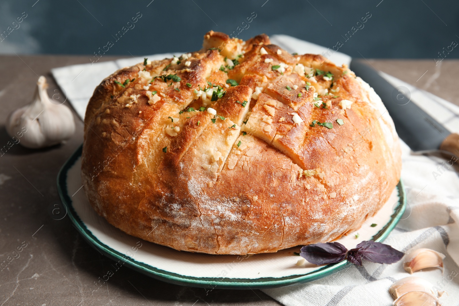 Photo of Plate with delicious homemade garlic bread on table