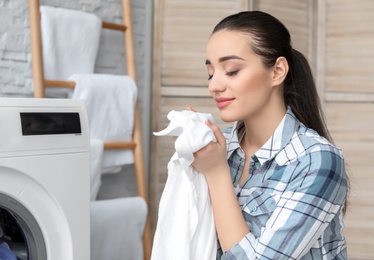 Photo of Young woman doing laundry at home