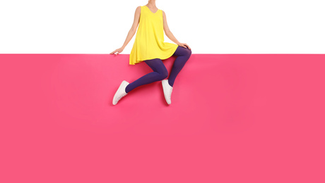 Photo of Woman wearing purple tights and stylish shoes sitting on color background, closeup