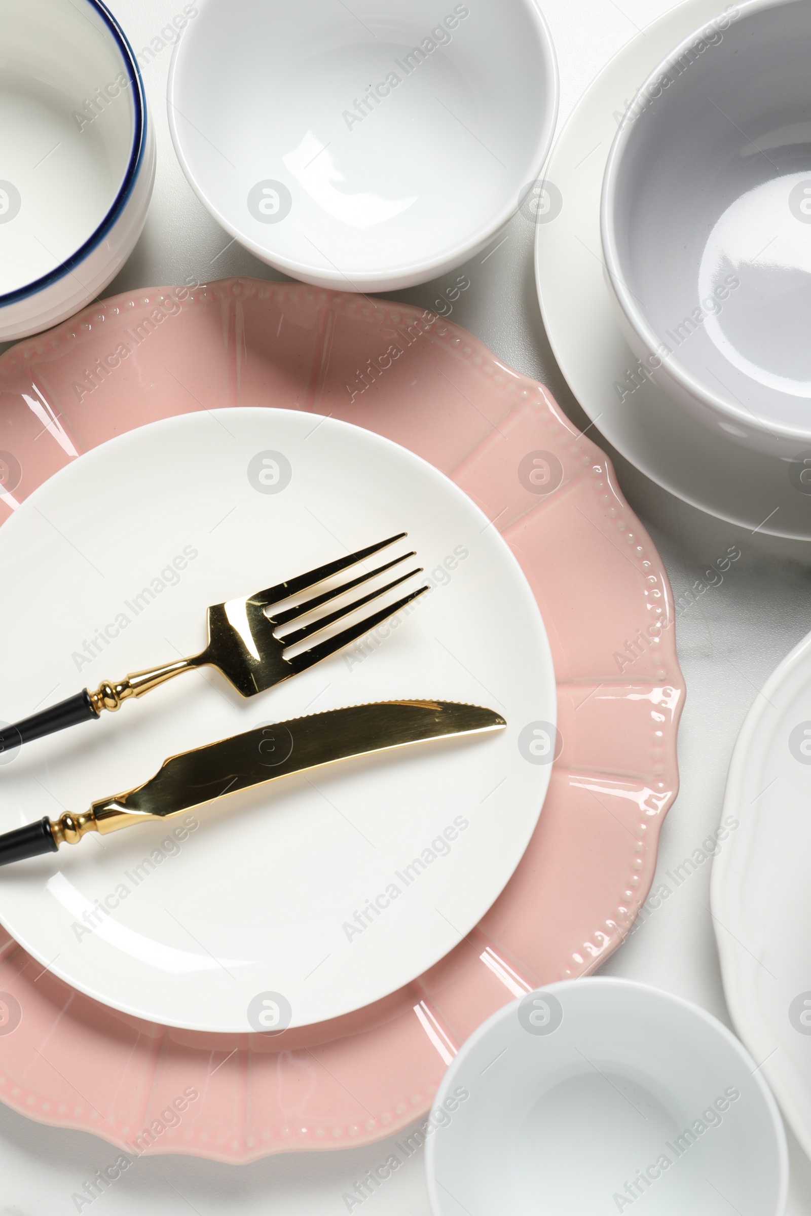 Photo of Beautiful ceramic dishware and cutlery on white table, flat lay