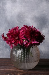 Photo of Beautiful pink chrysanthemum flowers in glass vase on wooden table