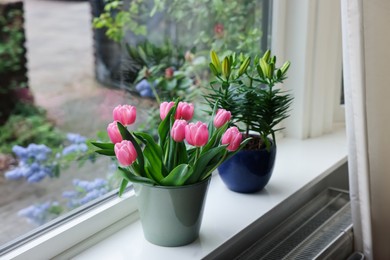 Photo of Beautiful bouquet with pink tulips and potted lily on white window sill indoors