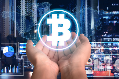 Image of Fintech concept. Woman demonstrating scheme with Bitcoin symbols against blurred cityscape, digital world map and charts