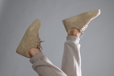 Man wearing stylish sneakers on light grey background, closeup