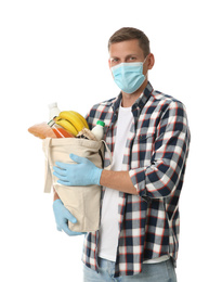 Photo of Male volunteer in protective mask and gloves with products on white background. Aid during coronavirus quarantine