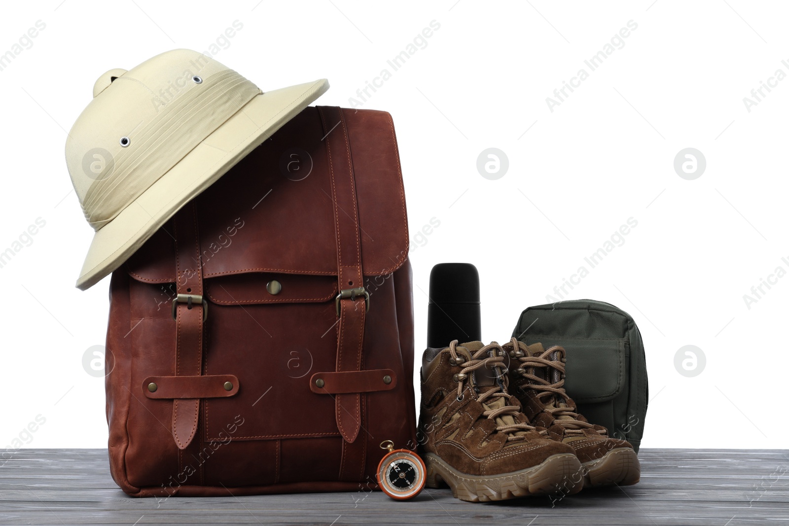 Photo of Set of camping equipment for tourist on wooden surface against white background