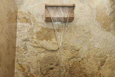 Waterfall shower with running water in spa center