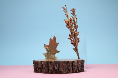 Photo of Autumn presentation for product. Wooden stump, geometric figure and golden leaves on color background