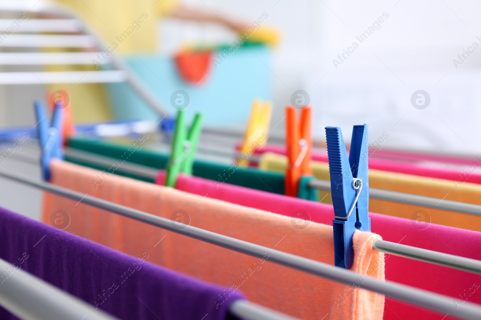 Photo of Clean laundry hanging on drying rack indoors, closeup