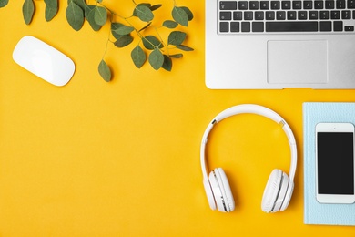 Photo of Flat lay composition with headphones, smartphone, laptop and space for text on color background