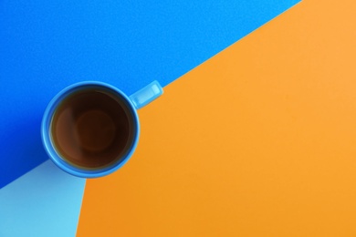 Cup of tea on color background, top view. Space for text