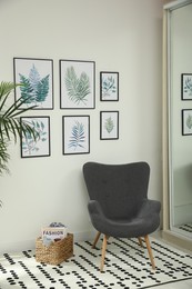 Beautiful paintings of tropical leaves on white wall in room interior