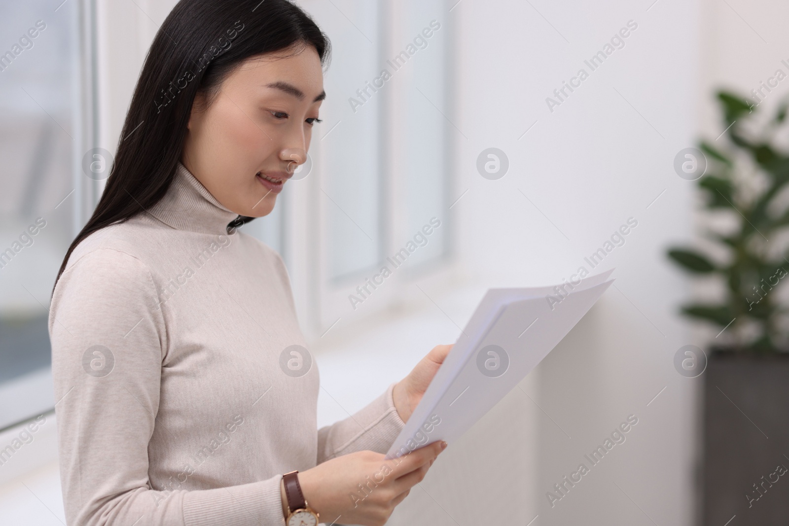 Photo of Portrait of smiling businesswoman with documents in office