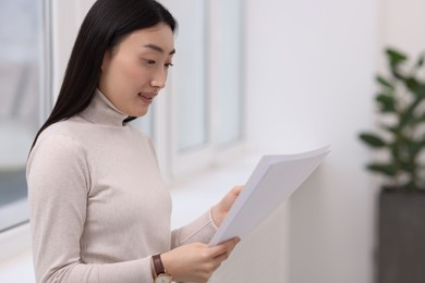 Photo of Portrait of smiling businesswoman with documents in office