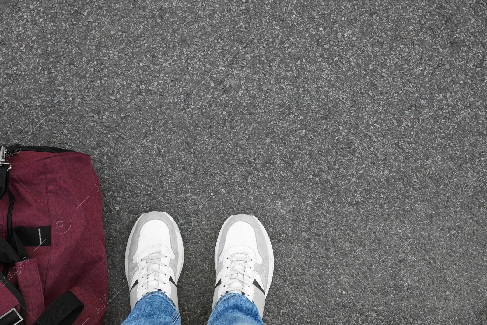 Photo of Man with bag standing on asphalt, top view. Space for text