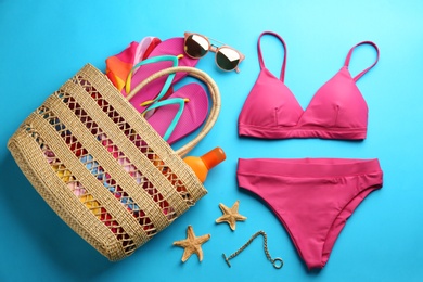 Photo of Beautiful pink bikini and beach accessories on light blue background, flat lay