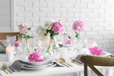 Stylish table setting with beautiful peonies in dining room